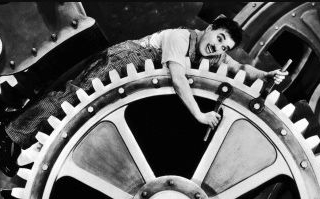 Foto do Charles Chaplin - sobre habitos repetitivos, numa cena de filme em que ele ficava no meio de engrenagens de uma fábrica, realizando tarefas repetitivas, como um robô